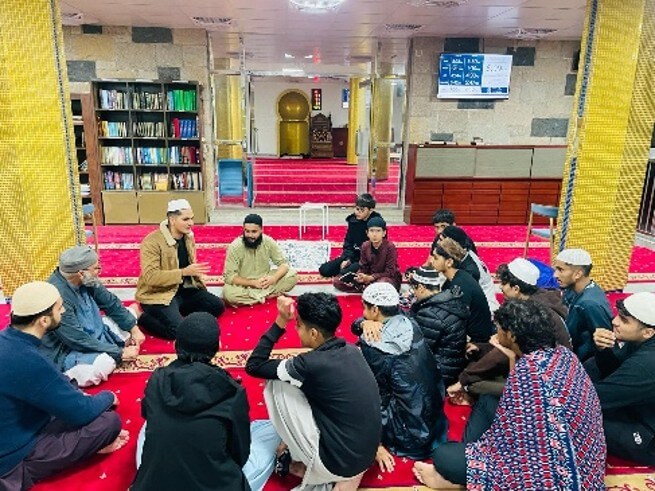 Students seated in a circle during training camp at Masjid